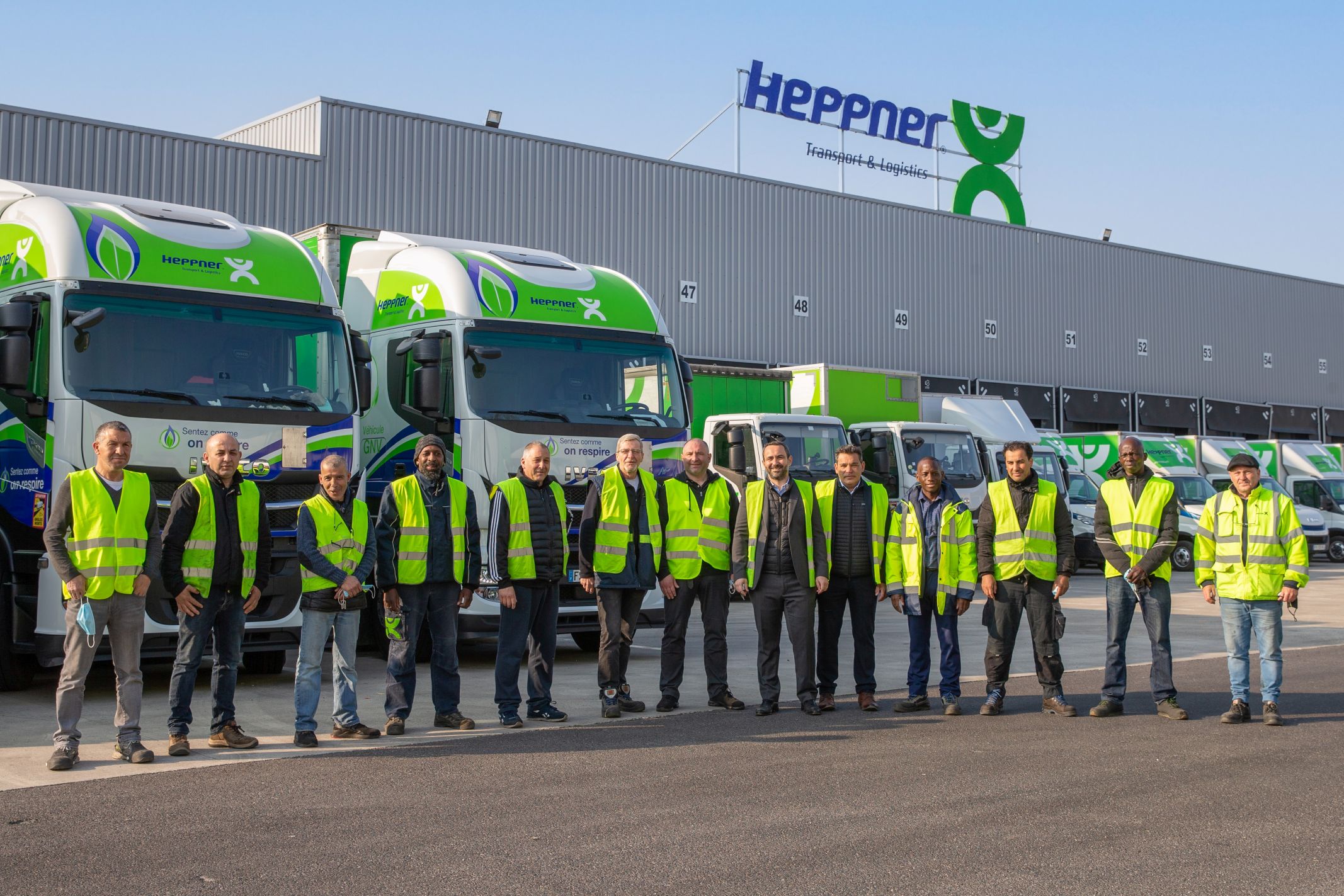 Group of employees in front of an agency and Heppner lorries